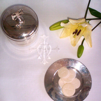 credence linen with holy communion and a yellow flower placed on topaltar linens