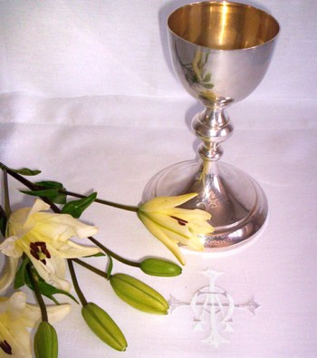 altar cloth with yellow flower and chalice placed on itlinens